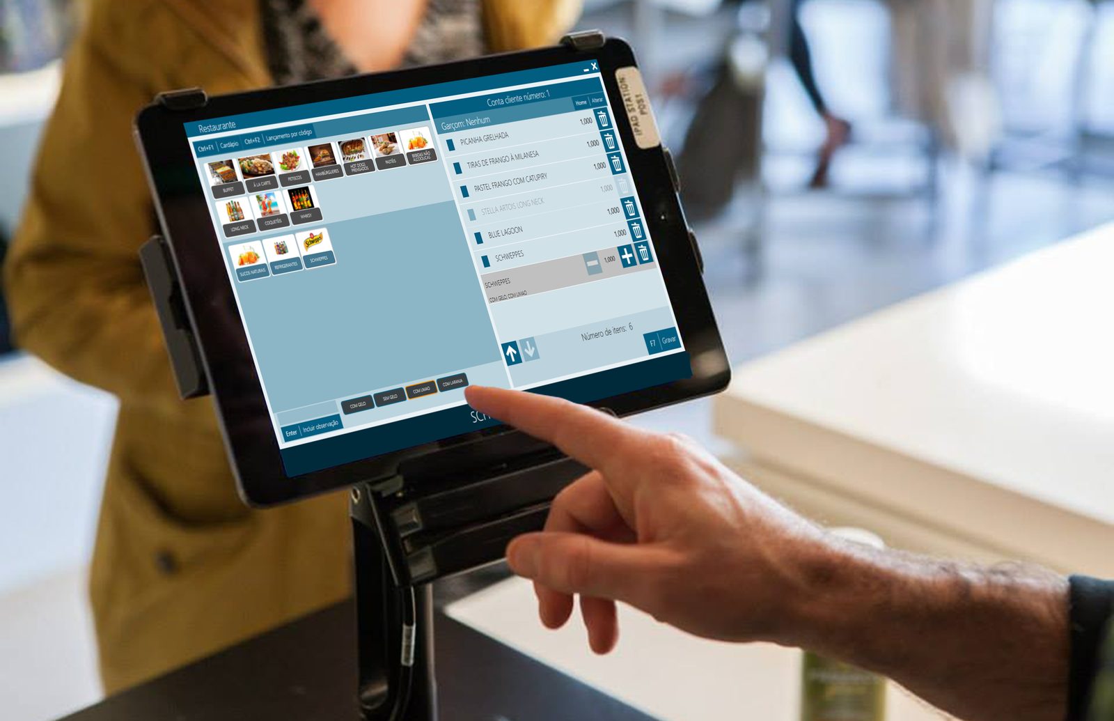 Atendente lançando pedido no tablet do restaurante